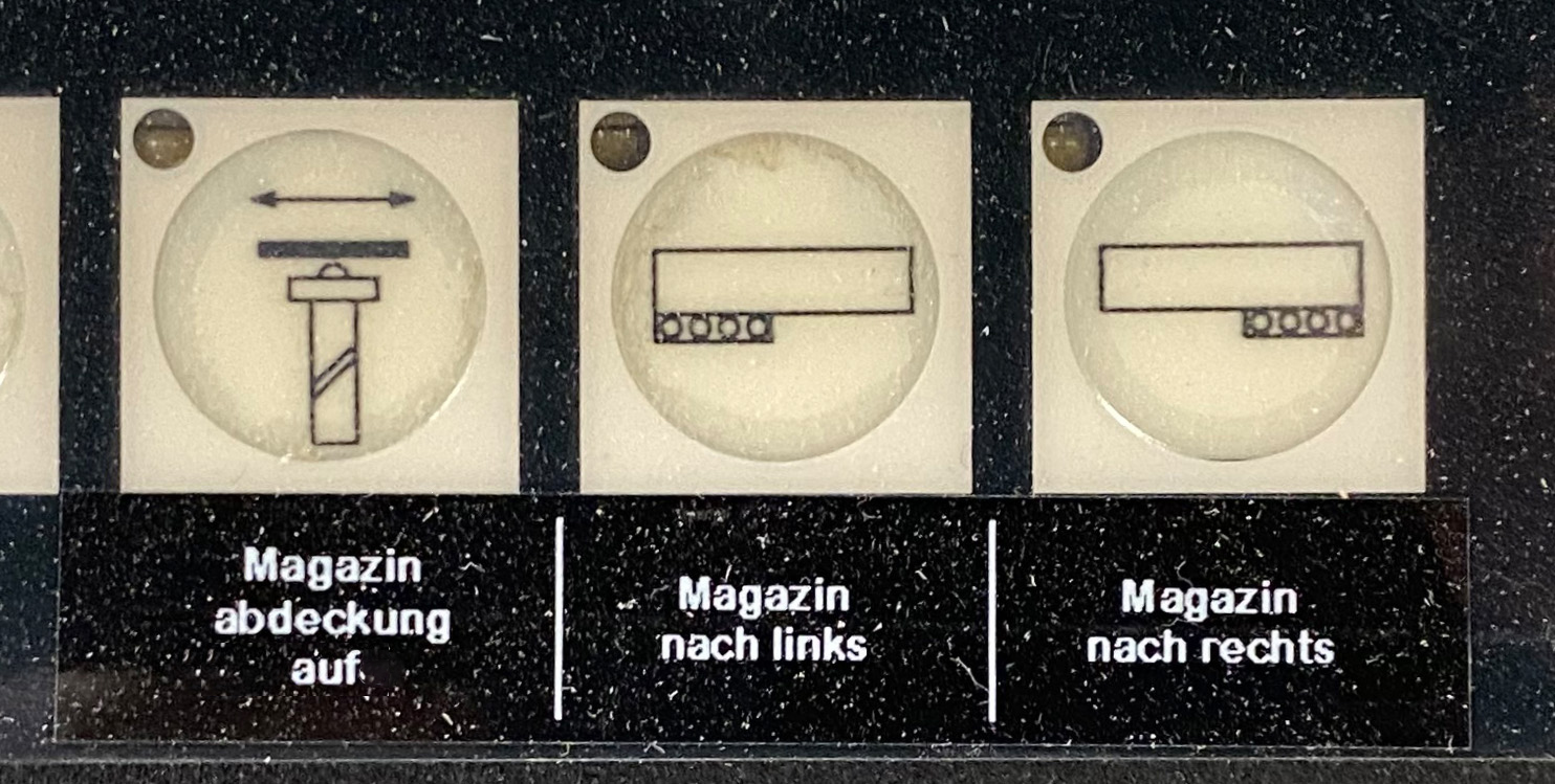 Tasten "Magazinabdeckung auf", "Magazin nach links" und "Magazin nach rechts"